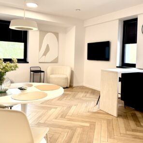Salon z telewizorem i strefą jadalną w apartamencie 12