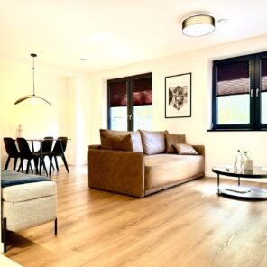 Salon z sofą i strefą jadalną w apartamencie 26 - Polna Park Duszniki-Zdrój