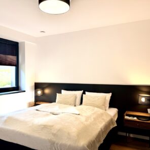 Sypialnia z podwójnym łóżkiem w apartamencie 26